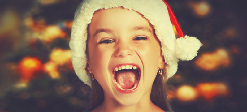 happy child girl in a Christmas hat waiting for a miracle